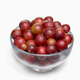 bowl of small round red berries on a white background